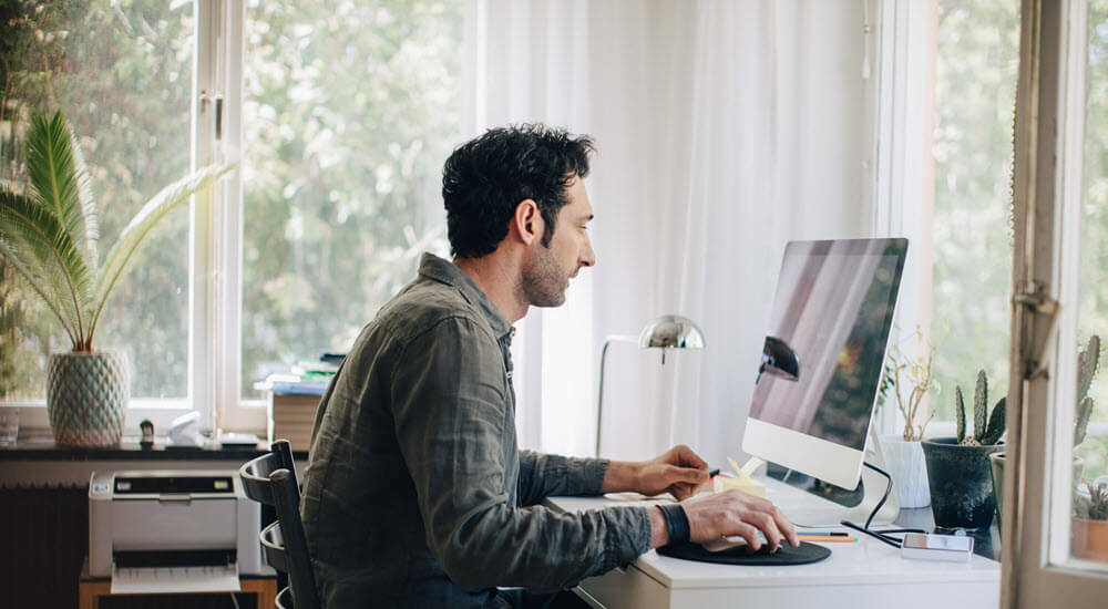 Man working from home catching up on his industry training through QBE webinars